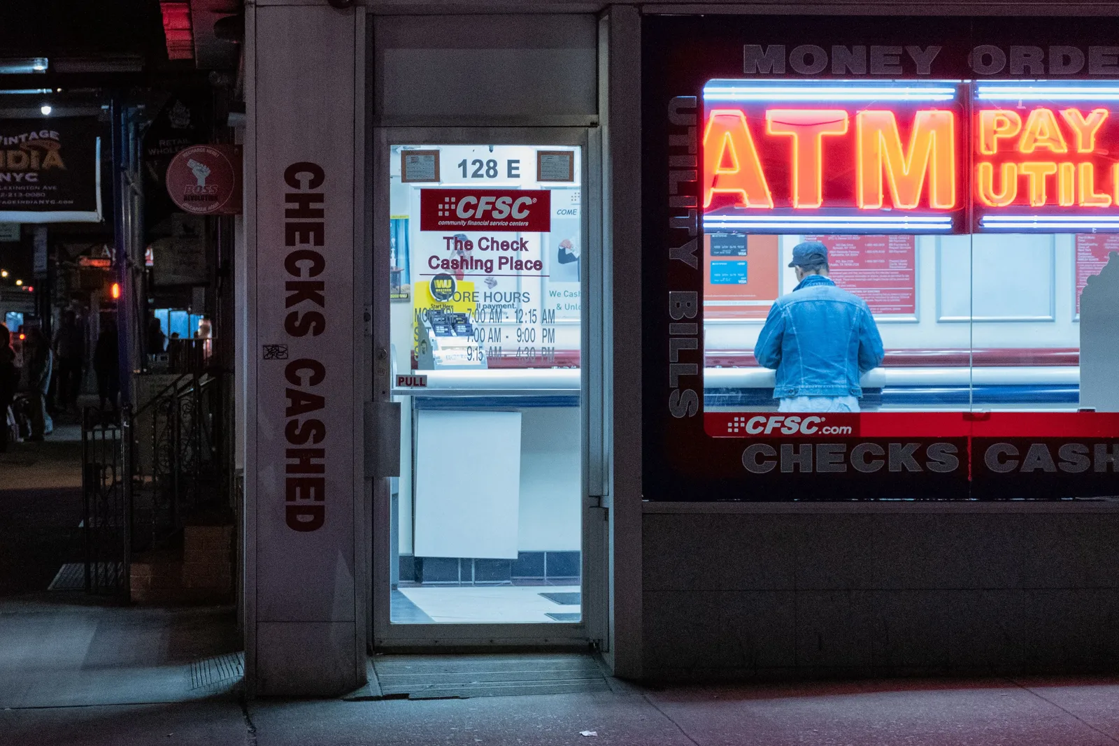 Neon-lit check cashing store with ATM services at night. ATM Route Fee Disclosure Requirements in British Columbia