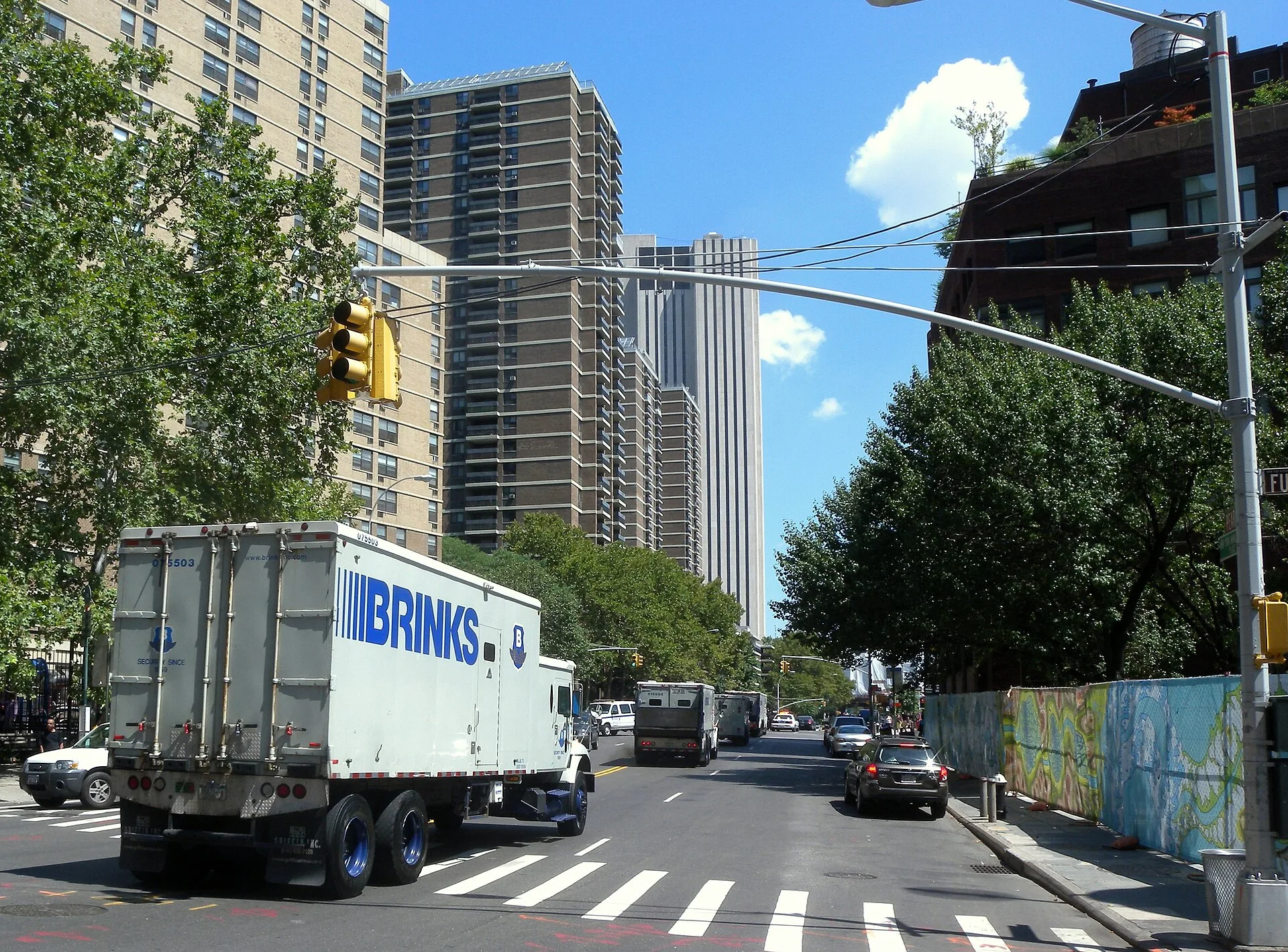 Looking east across Fulton Street as an armored truck goes northeast on Pearl Street on a sunny midday. Working with US armoured car services for ATM cash in transit